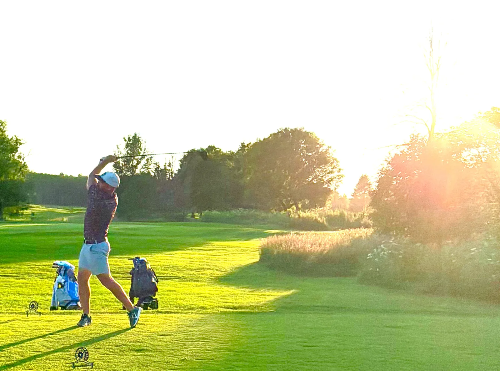 Golfer teeing off at sunset at Mill Run Golf Club in Uxbridge, Ontario
