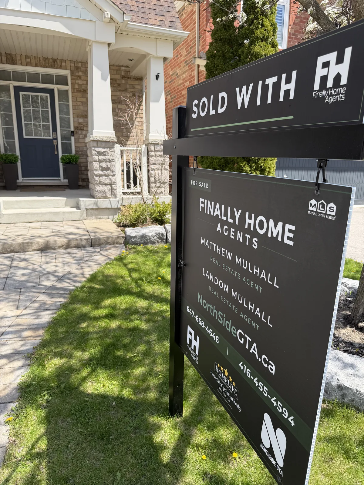 Sold With Finally Home Agents sign in front of a brick two-storey home in Newmarket, Ontario